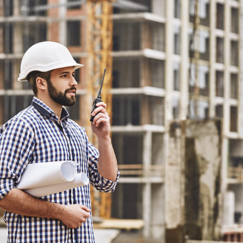 working-process-professional-young-construction-builder-white-protective-helmet-talking 1